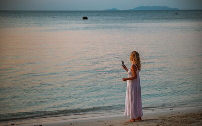 Femme au téléphone sur une plage