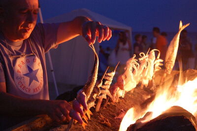 Un homme faisant griller du poisson sur la plage